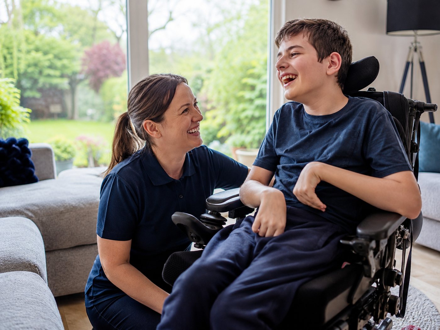 Carer sharing a laugh with a young client in his wheelchair at home